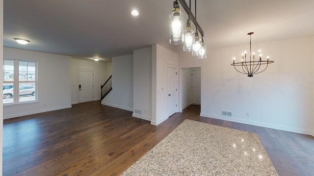 unfurnished room featuring a notable chandelier and dark hardwood / wood-style floors