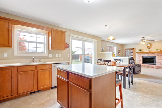 kitchen featuring a center island, decorative light fixtures, sink, and a wealth of natural light