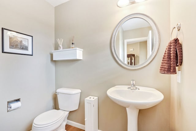 bathroom featuring hardwood / wood-style floors and toilet