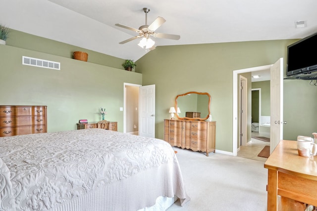 carpeted bedroom with ceiling fan, vaulted ceiling, and ensuite bath