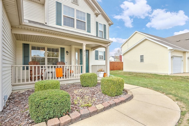 property entrance with covered porch, a lawn, and a garage