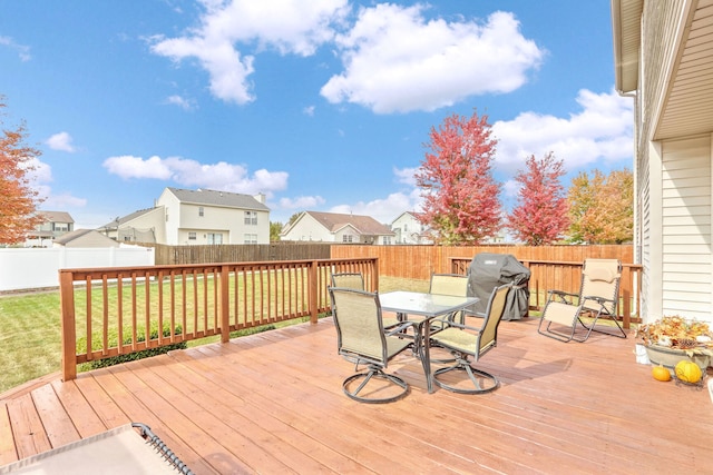 wooden terrace with area for grilling and a yard