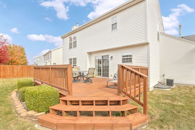 rear view of house featuring central air condition unit, a deck, and a lawn