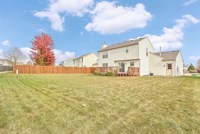 rear view of property with a deck and a lawn