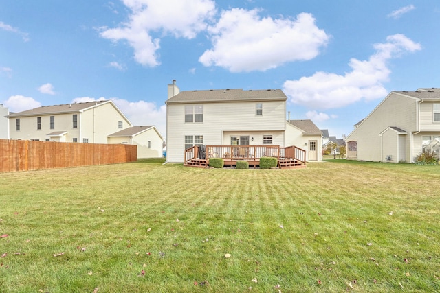 back of house with a wooden deck and a lawn