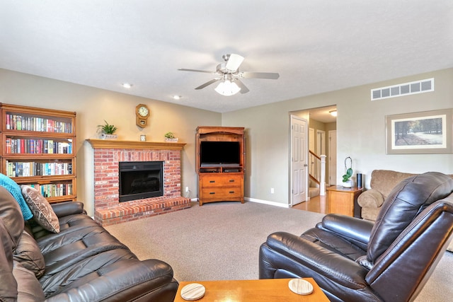 carpeted living room with a fireplace and ceiling fan