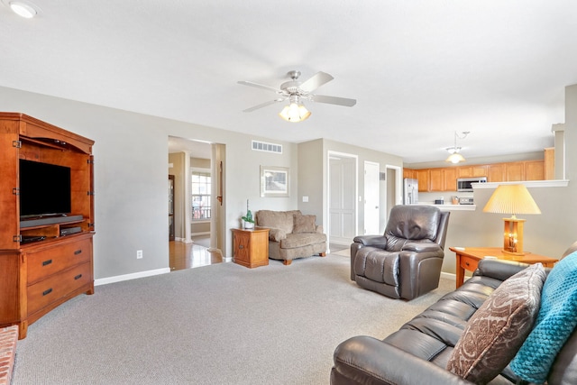 carpeted living room with ceiling fan