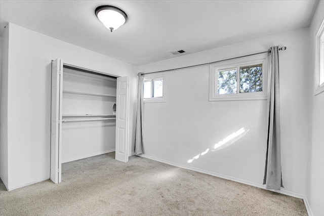 unfurnished bedroom with a closet and light carpet