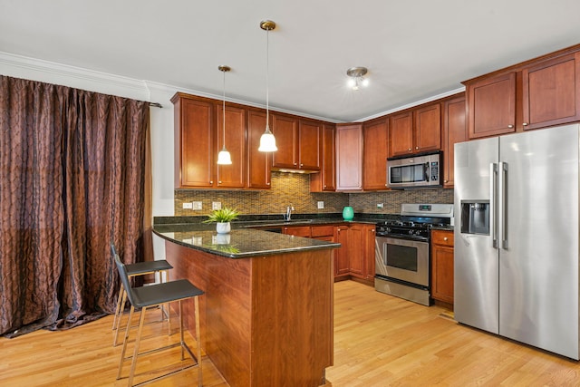 6832 S Cornell Ave Unit 1, Chicago, IL 60649 - kitchen with a peninsula, light wood-style flooring, backsplash, decorative light fixtures, and appliances with stainless steel finishes