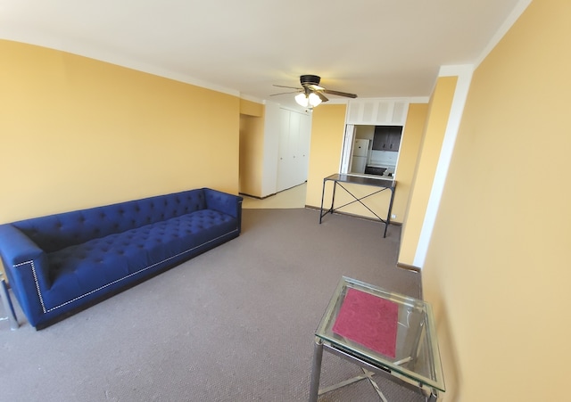 carpeted living room with ceiling fan and ornamental molding