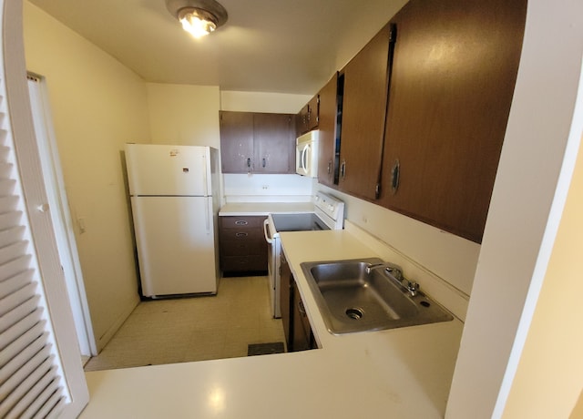 kitchen with white appliances, dark brown cabinets, sink, and kitchen peninsula