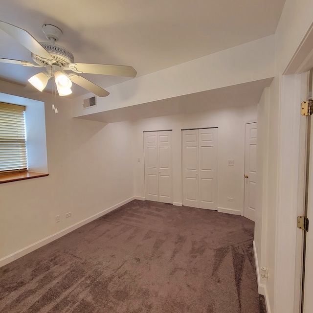 interior space with ceiling fan and dark colored carpet