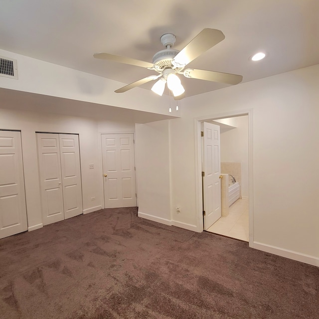 unfurnished bedroom with connected bathroom, ceiling fan, multiple closets, and light colored carpet