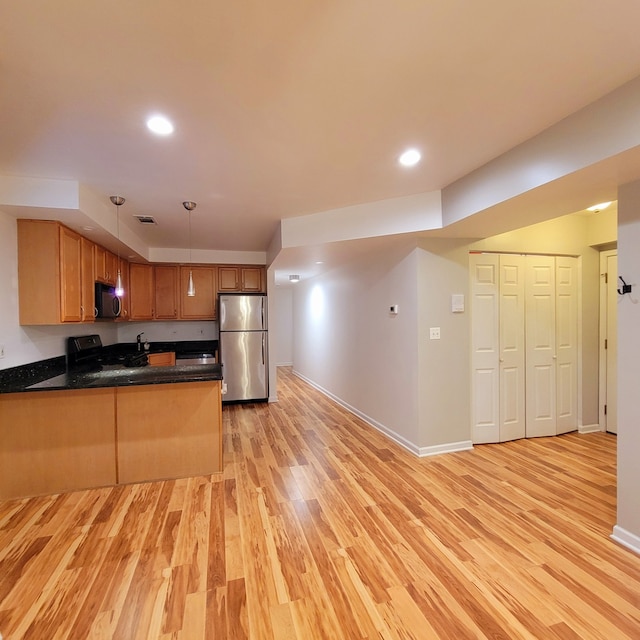 kitchen featuring stainless steel fridge, kitchen peninsula, black range, and light hardwood / wood-style floors