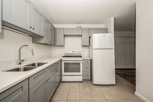 kitchen featuring white appliances, light tile patterned flooring, sink, and gray cabinets