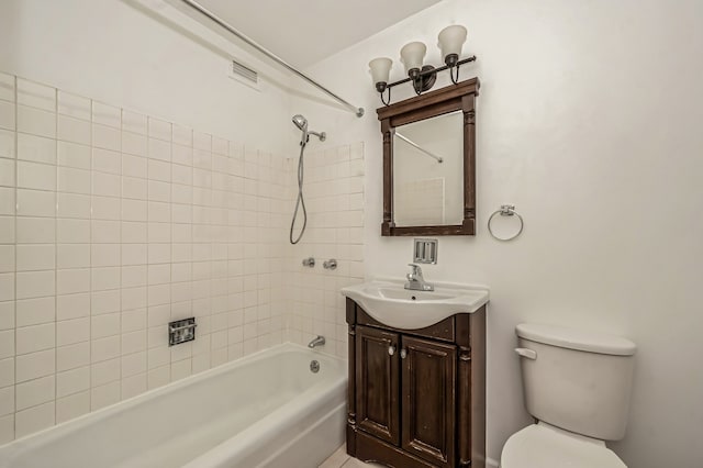 full bathroom with tiled shower / bath, vanity, and toilet