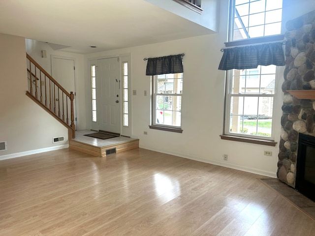 foyer entrance featuring light hardwood / wood-style floors, a healthy amount of sunlight, and a fireplace