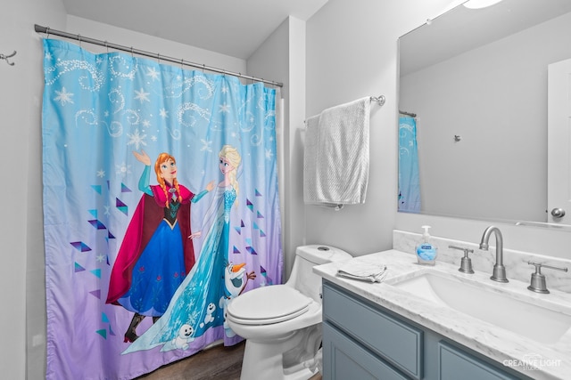 bathroom featuring a shower with shower curtain, hardwood / wood-style floors, vanity, and toilet