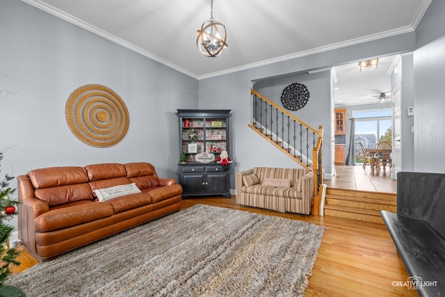 living room featuring crown molding, ceiling fan with notable chandelier, and hardwood / wood-style flooring