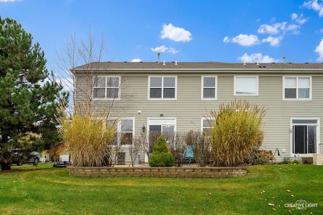 rear view of house featuring a yard