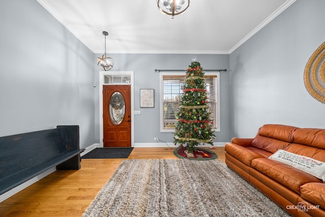 entrance foyer featuring a chandelier, light wood-type flooring, and crown molding