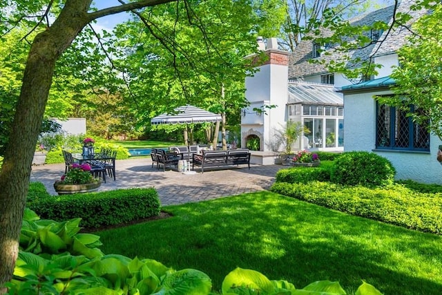 view of yard featuring a patio area and an outdoor fireplace