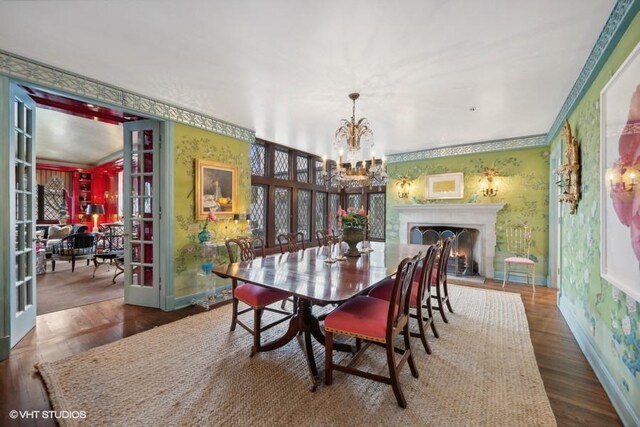 dining area featuring dark hardwood / wood-style flooring, a notable chandelier, crown molding, and french doors