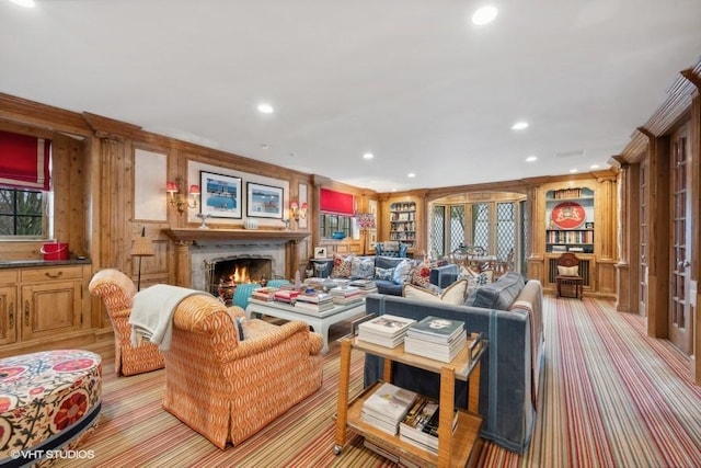 living room with crown molding, built in shelves, light carpet, and wood walls