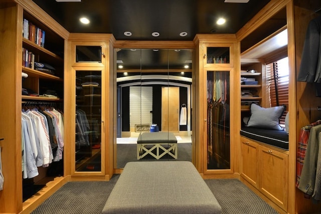 walk in closet featuring french doors and dark colored carpet