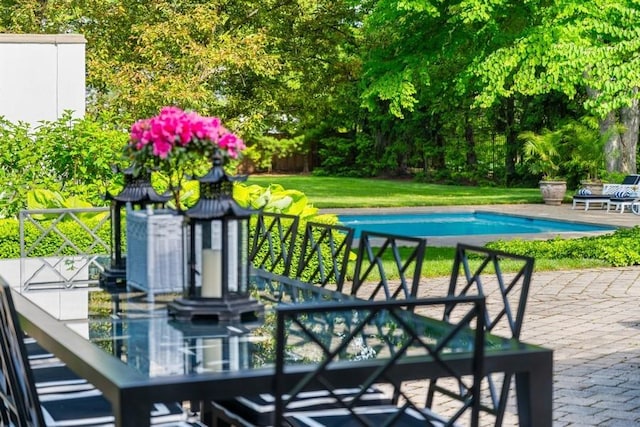 view of pool featuring a patio and a yard