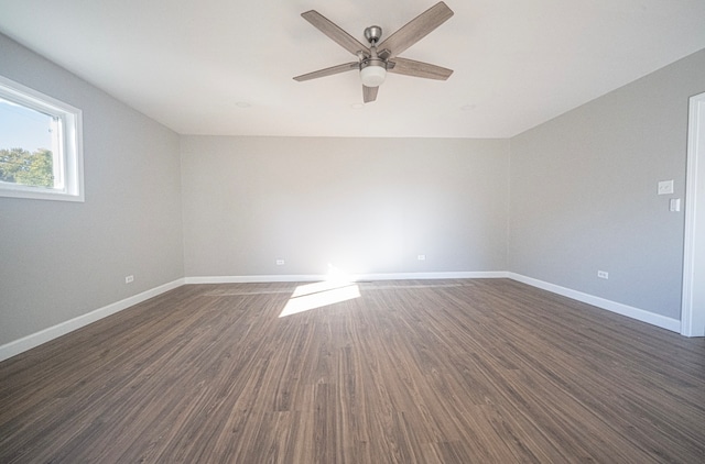 empty room with ceiling fan and dark hardwood / wood-style flooring