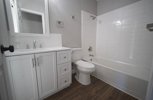 full bathroom with toilet, wood-type flooring, backsplash, tiled shower / bath, and vanity