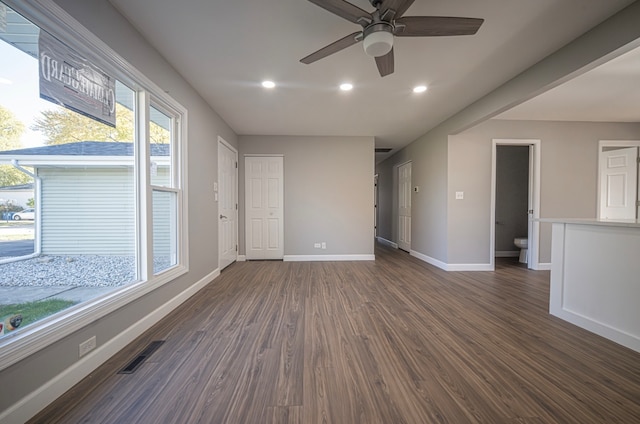 empty room with ceiling fan and dark hardwood / wood-style flooring