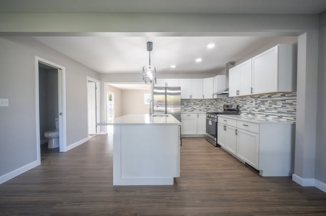 kitchen featuring tasteful backsplash, appliances with stainless steel finishes, dark hardwood / wood-style flooring, hanging light fixtures, and white cabinetry