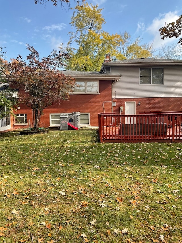 back of house with a wooden deck and a lawn