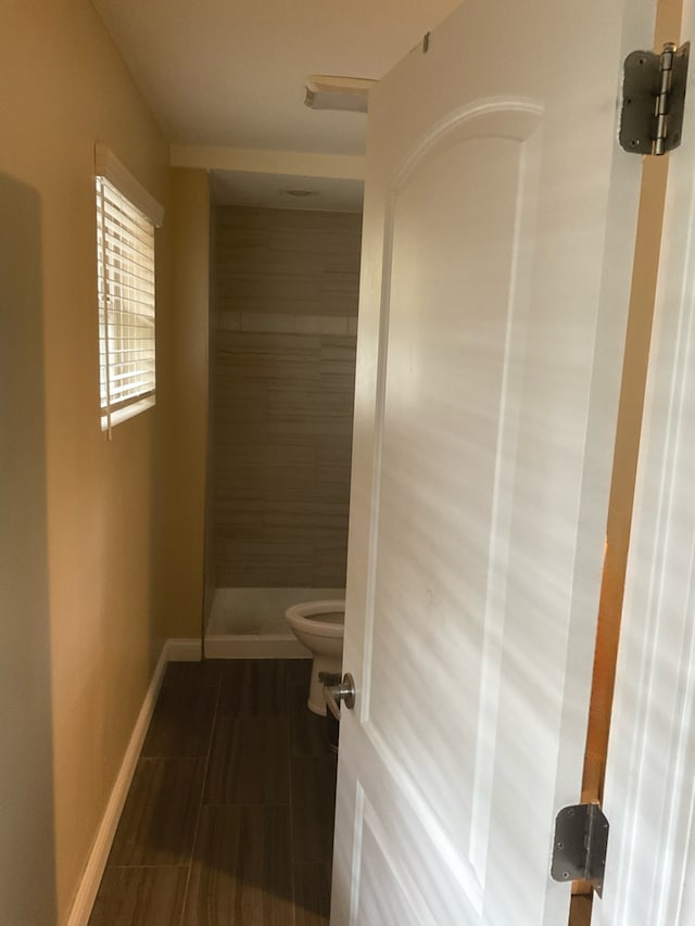 bathroom with toilet and tiled shower