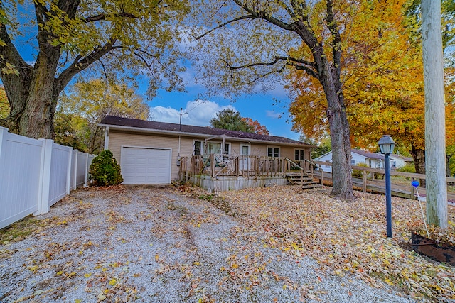 ranch-style home featuring a deck and a garage