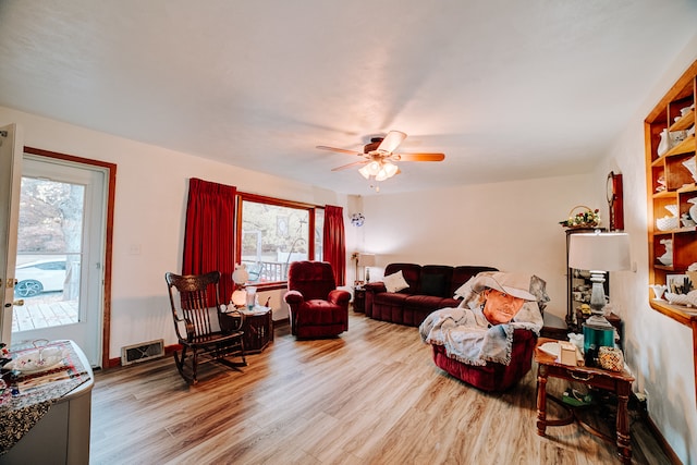 living room featuring light wood-type flooring, plenty of natural light, and ceiling fan