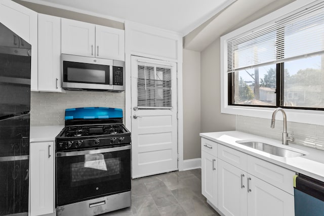 kitchen featuring backsplash, appliances with stainless steel finishes, sink, and white cabinets