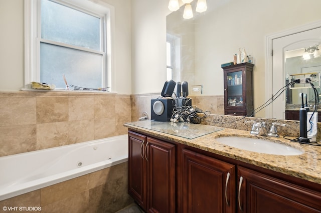 bathroom with vanity and tiled tub