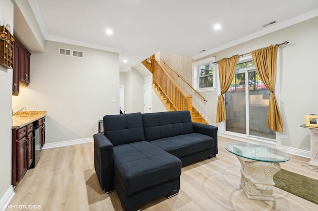 living room with ornamental molding and light wood-type flooring