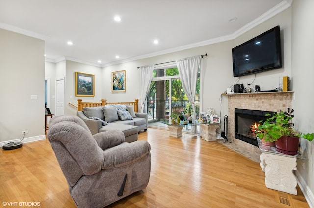 living room featuring crown molding, light hardwood / wood-style flooring, and a brick fireplace