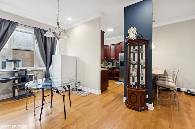 dining area with ornamental molding, light hardwood / wood-style flooring, and a notable chandelier