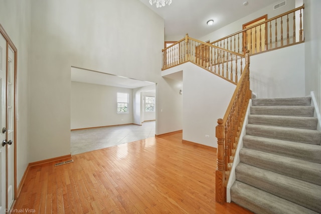 interior space with a towering ceiling and hardwood / wood-style floors