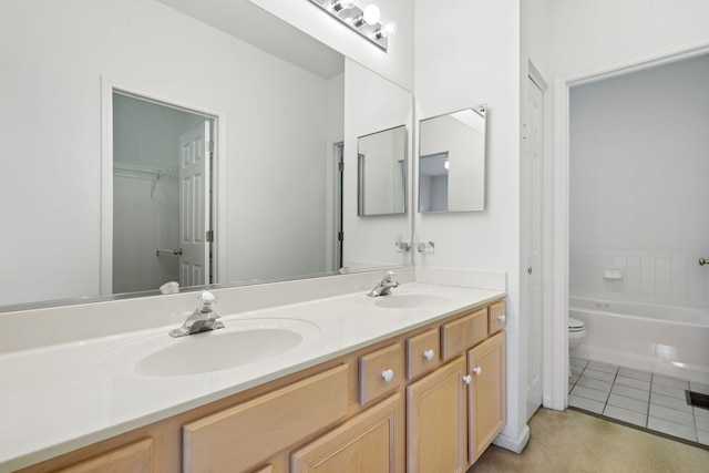 bathroom with vanity, a tub, toilet, and tile patterned flooring