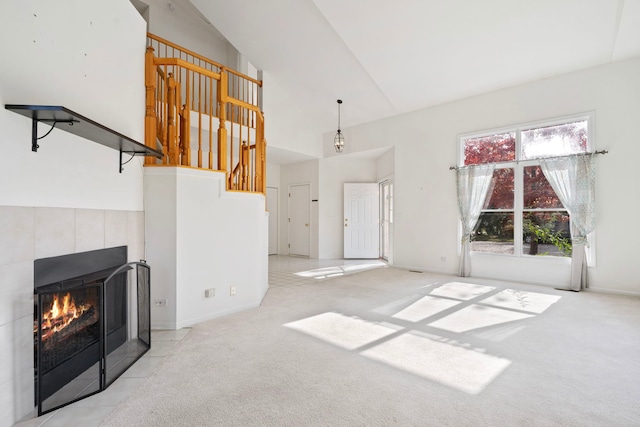 unfurnished living room with light carpet, vaulted ceiling, and a tile fireplace