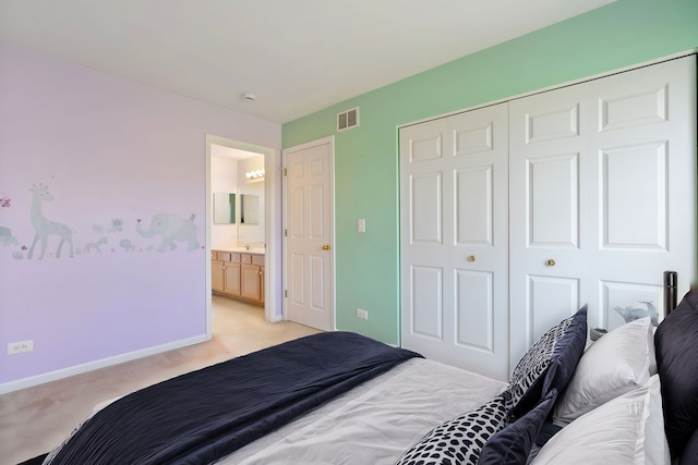 carpeted bedroom with a closet and ensuite bath