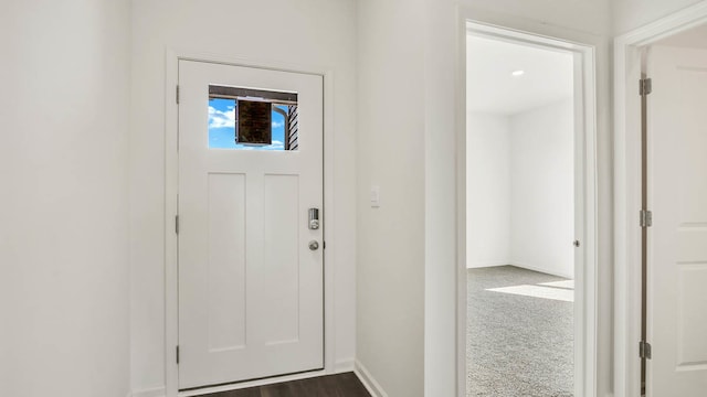 entrance foyer featuring dark carpet