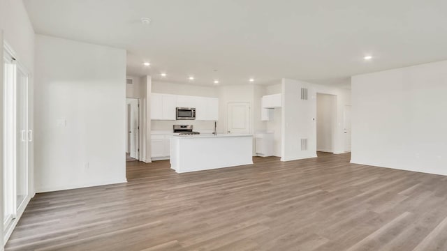 unfurnished living room with light hardwood / wood-style flooring and sink