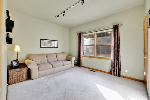 carpeted living room featuring track lighting